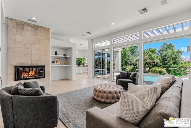 tiled living room featuring built in shelves and a fireplace