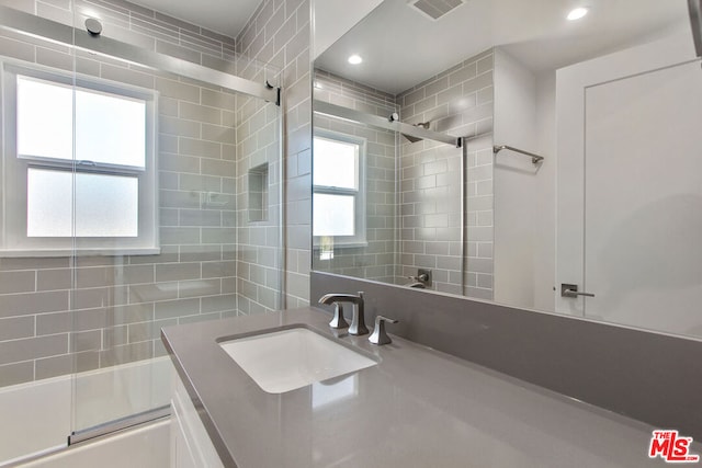 bathroom with vanity and combined bath / shower with glass door