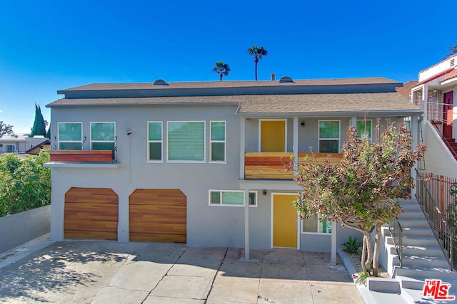 view of front of house with a garage and a patio