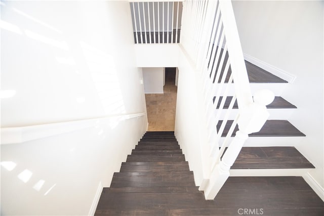 staircase featuring dark hardwood / wood-style floors