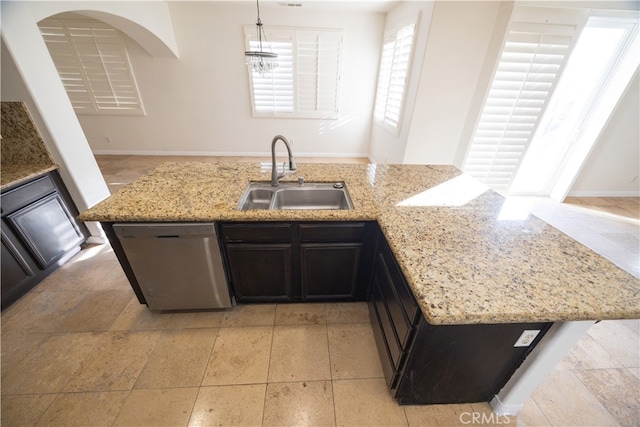 kitchen with light tile patterned floors, dishwasher, light stone counters, hanging light fixtures, and sink