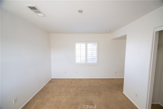 spare room featuring light colored carpet