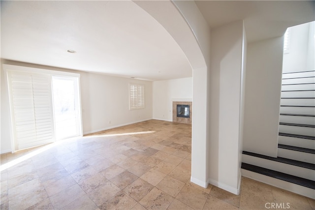 unfurnished living room with a fireplace and light tile patterned floors