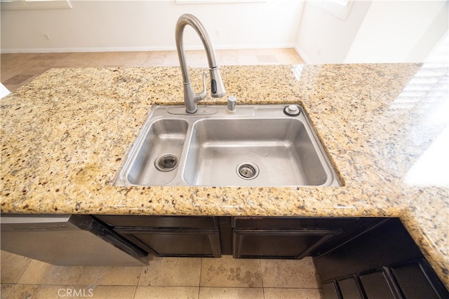 room details featuring sink, light tile patterned flooring, and light stone countertops