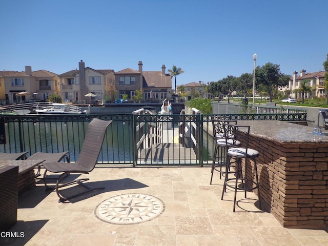 view of patio / terrace featuring a water view and an outdoor wet bar