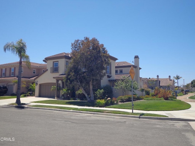 mediterranean / spanish-style house with a front yard and a garage