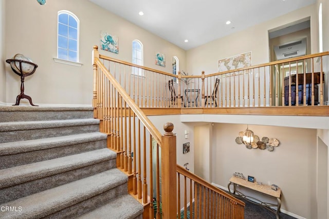 stairway with a high ceiling and an inviting chandelier