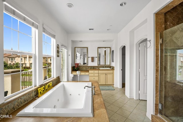 bathroom with tile patterned floors, vanity, and plus walk in shower