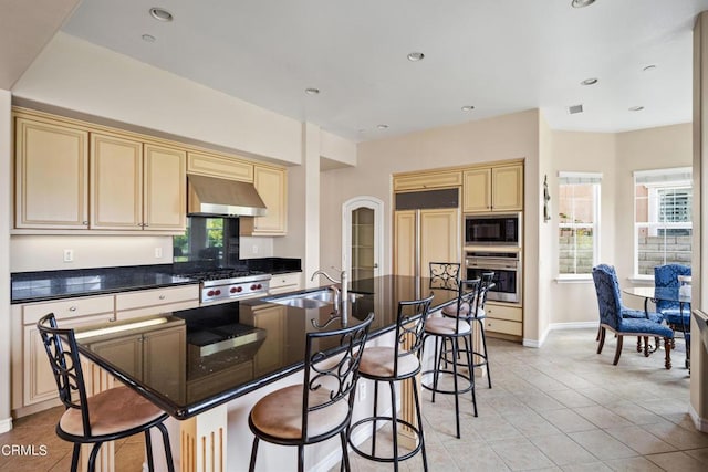 kitchen with sink, built in appliances, an island with sink, range hood, and light tile patterned flooring