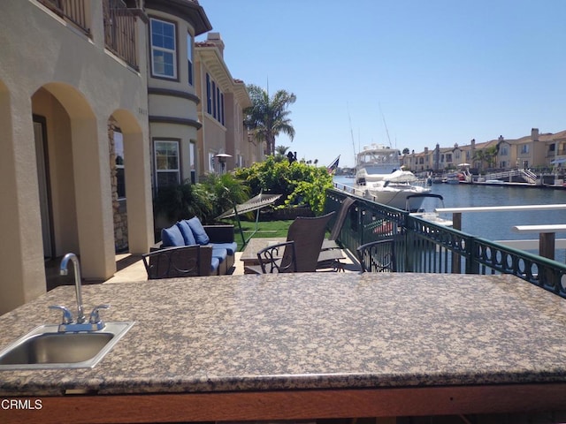 view of patio / terrace featuring an outdoor living space, sink, and a water view