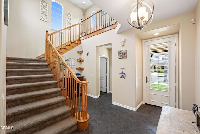 foyer entrance with an inviting chandelier and dark tile patterned floors