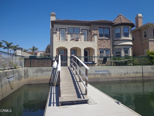 view of dock with a water view and a balcony