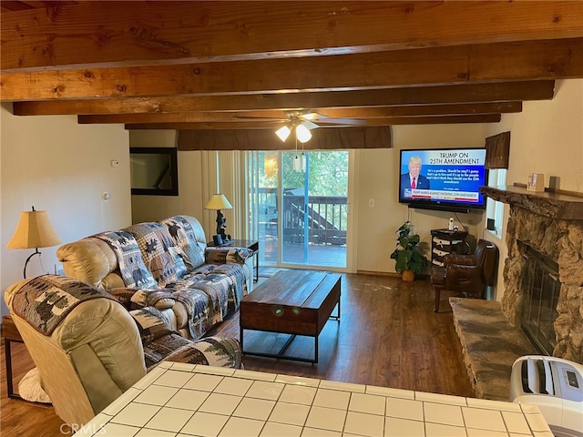 living room with beamed ceiling, wood-type flooring, a fireplace, and ceiling fan