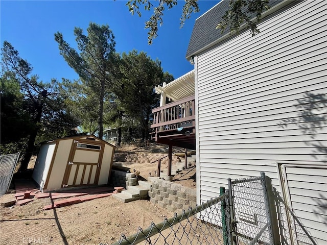 view of side of home featuring a storage unit and a wooden deck