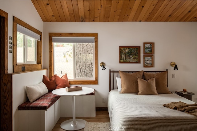 bedroom with vaulted ceiling, light hardwood / wood-style floors, and wooden ceiling