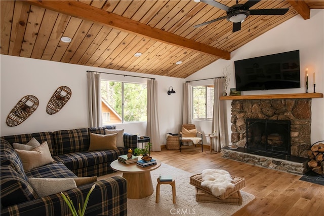 living room with ceiling fan, hardwood / wood-style flooring, a fireplace, and lofted ceiling with beams