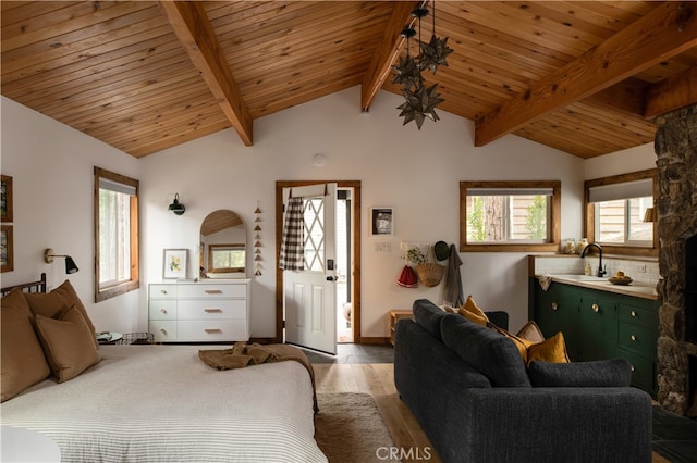 bedroom featuring vaulted ceiling with beams, light hardwood / wood-style floors, wooden ceiling, and sink