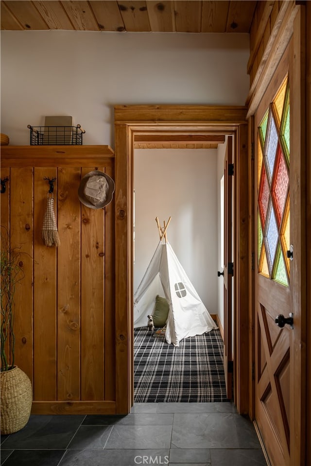 mudroom with wood ceiling and dark tile patterned floors