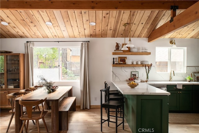 interior space with lofted ceiling with beams, light wood-type flooring, green cabinetry, decorative backsplash, and wooden ceiling