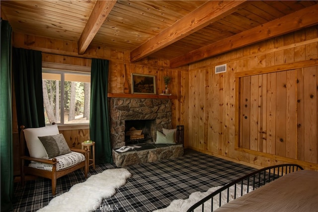 bedroom with wooden walls, wood ceiling, and a fireplace