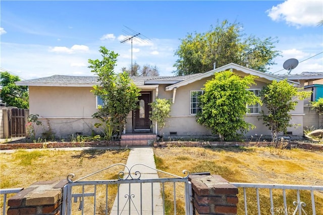 view of front of house with crawl space, a fenced front yard, a gate, and stucco siding