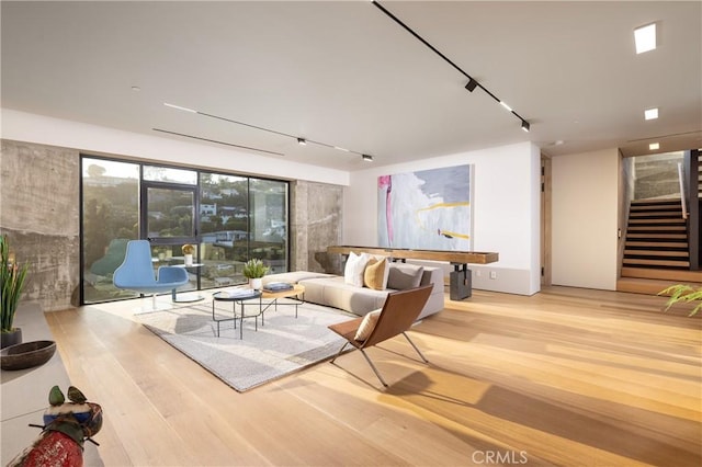 living room with rail lighting and light hardwood / wood-style floors