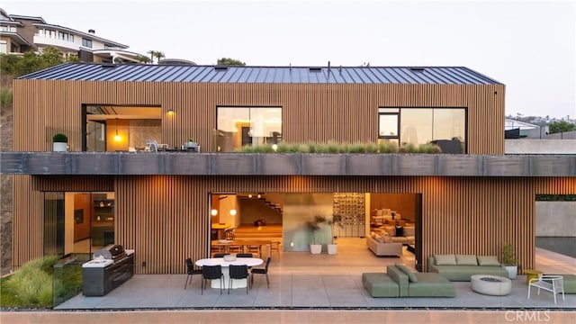 rear view of house with an outdoor hangout area and a patio area