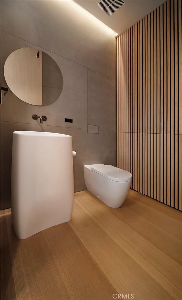 bathroom featuring toilet, hardwood / wood-style flooring, and vanity