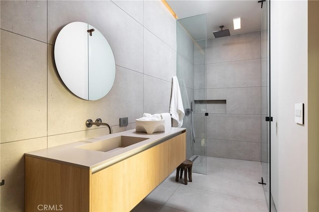 bathroom featuring a shower, tile walls, and vanity