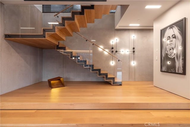 staircase with hardwood / wood-style floors