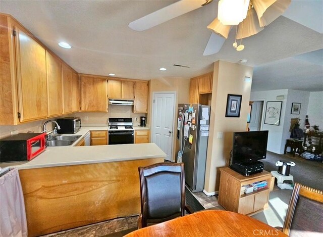 kitchen with black gas range, sink, kitchen peninsula, ceiling fan, and stainless steel fridge with ice dispenser