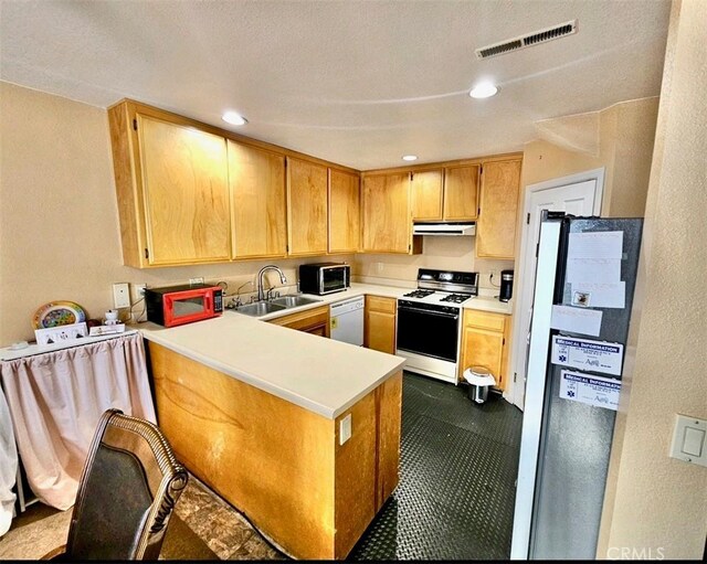 kitchen featuring sink, white appliances, and kitchen peninsula