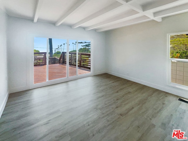 spare room with beam ceiling and wood-type flooring