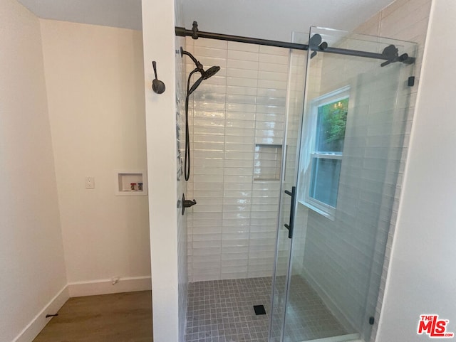 bathroom featuring a shower with door and hardwood / wood-style flooring