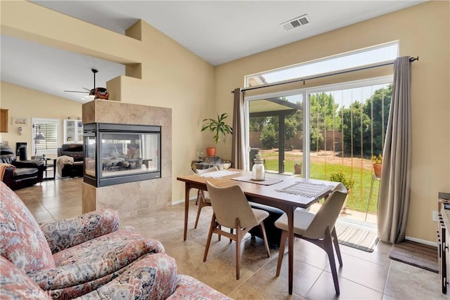 dining area with ceiling fan, a healthy amount of sunlight, light tile patterned floors, and vaulted ceiling