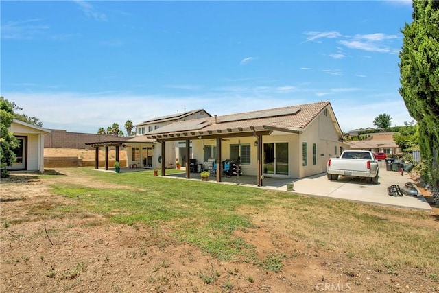 back of property with a lawn and a patio area