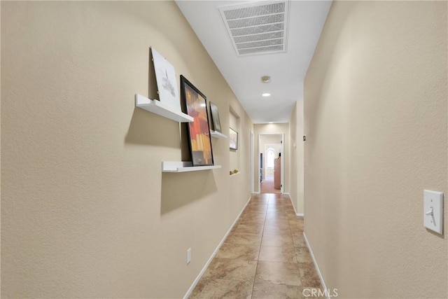 hall with visible vents and baseboards