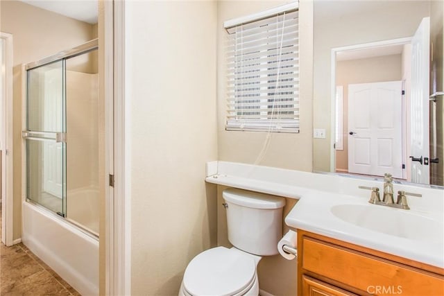 full bath featuring vanity, toilet, combined bath / shower with glass door, and tile patterned flooring