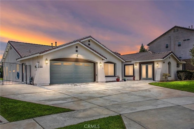 view of front of property with stucco siding, concrete driveway, an attached garage, and a tile roof