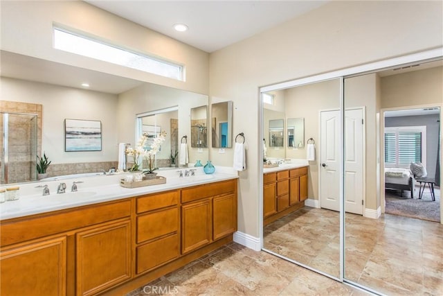 ensuite bathroom featuring a shower stall, plenty of natural light, and a sink