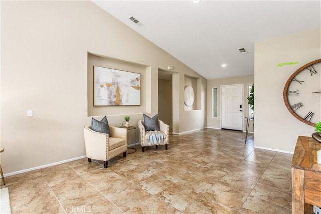 sitting room featuring visible vents, baseboards, and lofted ceiling