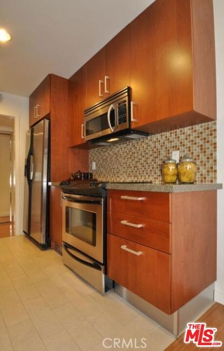 kitchen with decorative backsplash, stainless steel appliances, and light tile patterned floors