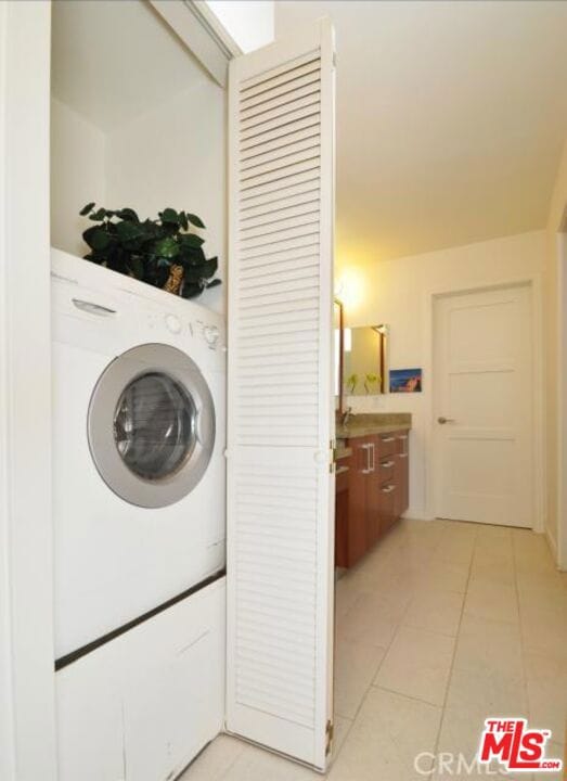 washroom with washer / clothes dryer and light tile patterned floors