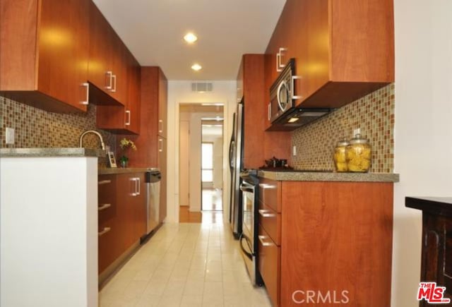 kitchen featuring light tile patterned floors, tasteful backsplash, and stainless steel appliances