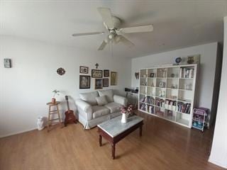 living room featuring hardwood / wood-style floors and ceiling fan