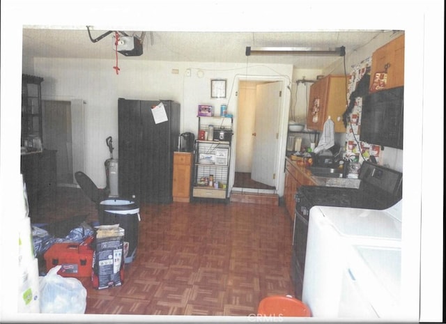 kitchen with dark parquet floors, washer and dryer, and sink