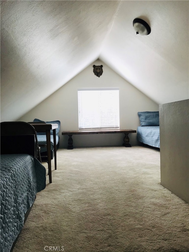 bedroom featuring lofted ceiling, light colored carpet, and a textured ceiling