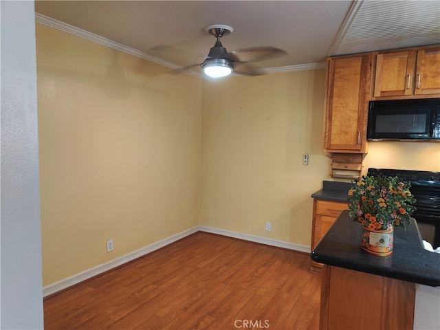 kitchen featuring range, crown molding, light wood-type flooring, and ceiling fan