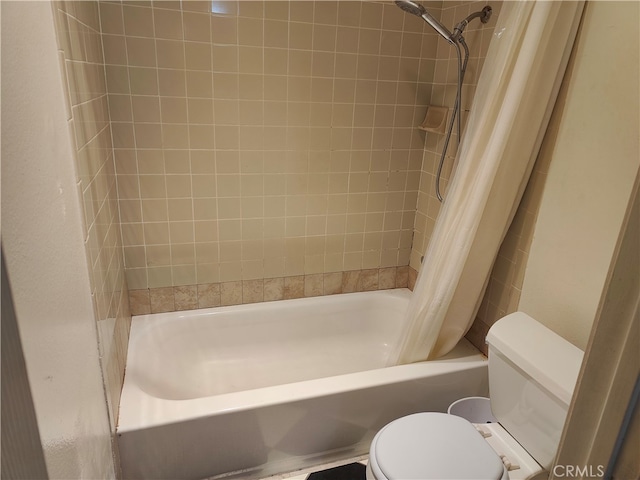 bathroom featuring shower / tub combo and toilet