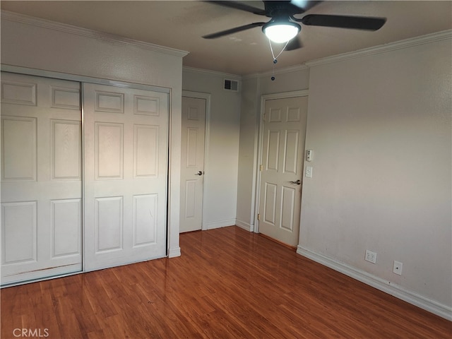 unfurnished bedroom featuring crown molding, ceiling fan, hardwood / wood-style floors, and a closet